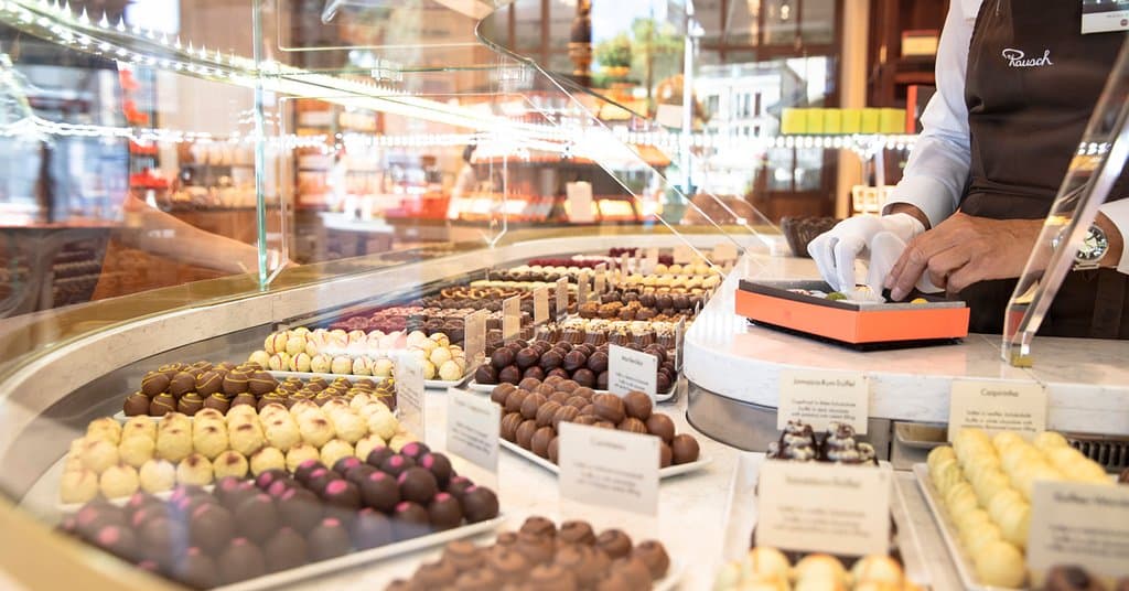 Verkäuferin stellt individuelle Auswahl an Pralinen zusammen