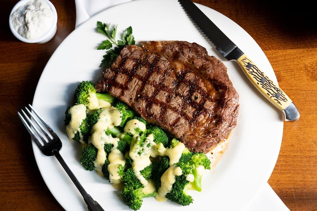 Top Sirloin Steak with your choice of side, pictured with seasonal broccoli and Béarnaise sauce