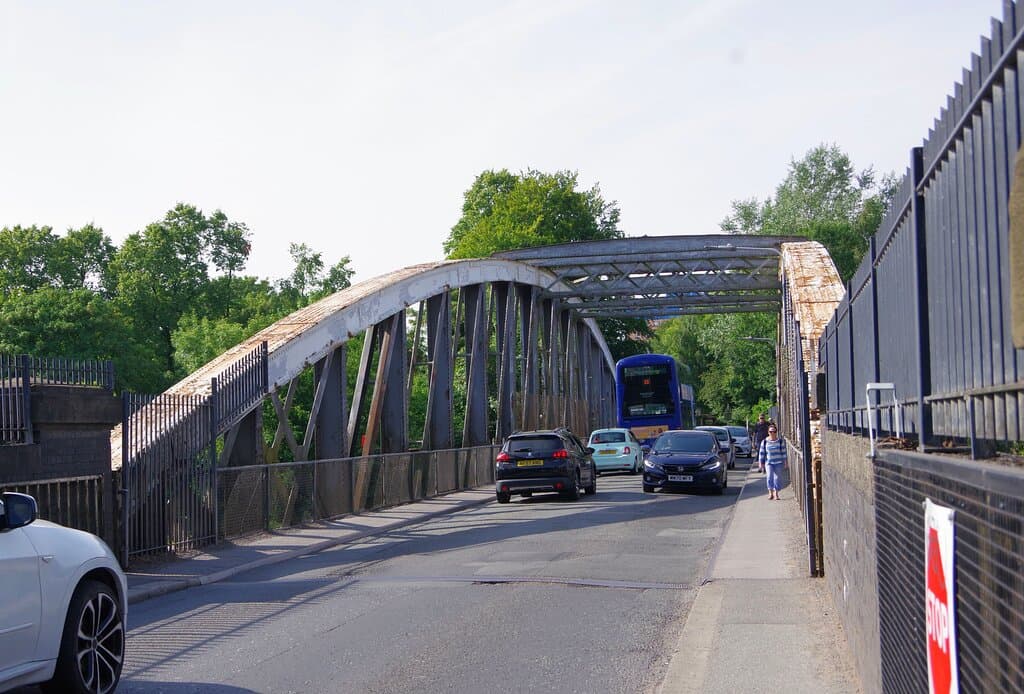 Traffic crossing the bridge in July 2022. The break in the road at the end of the bridge is where the bridge starts to swing.
