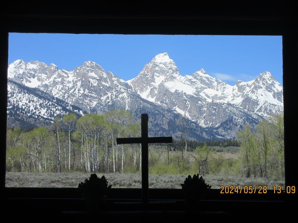 The view of the Grand Tetons through the window behind the altar.