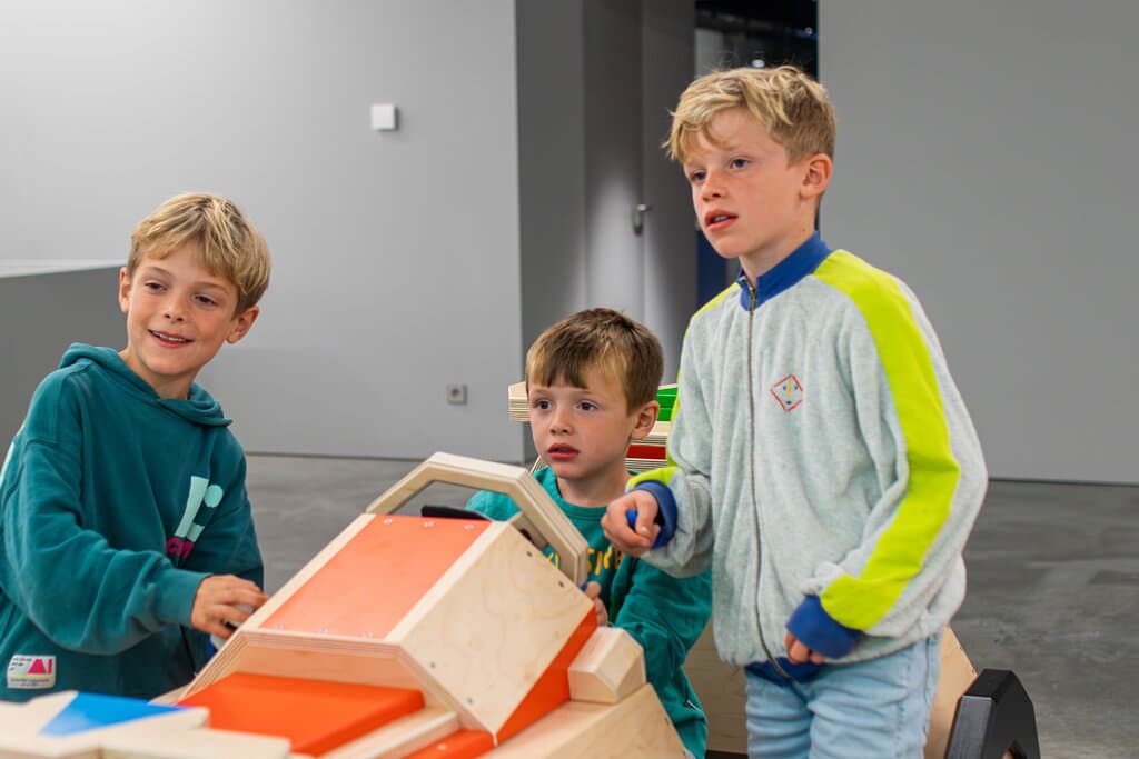 Three children are playing a race game at the museum.