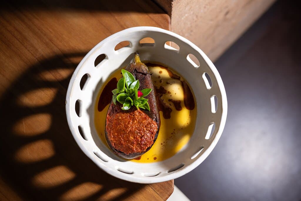 Slow-charred eggplant on the grill and finished in the wood-fired oven, served with Ord River chickpea hummus and rummaniyeh sauce (pomegranate stew).
